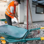 Worker Clearing Debris with Wheelbarrow
