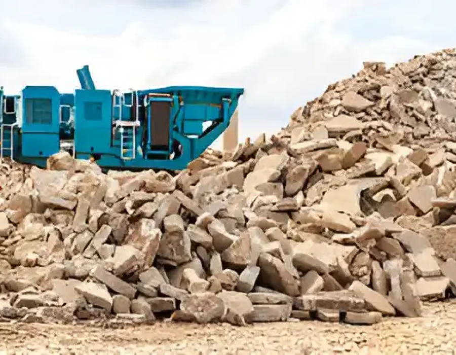 Blue crusher machine processing concrete debris into recyclable materials