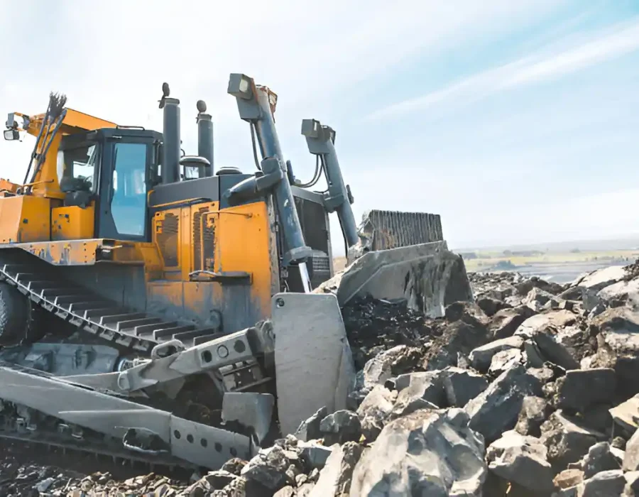 Close-up of an excavator bucket removing rubble during site demolition and debris clearing.
