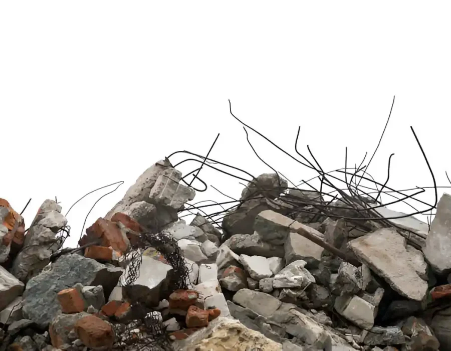 Pile of concrete rubble and exposed rebar from demolition work.