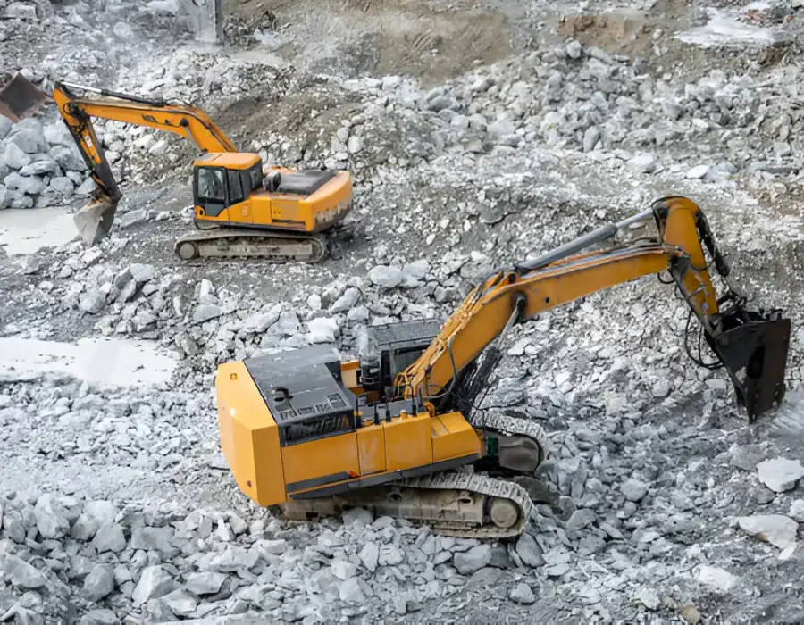 Excavators clearing debris and rubble at a demolition site.