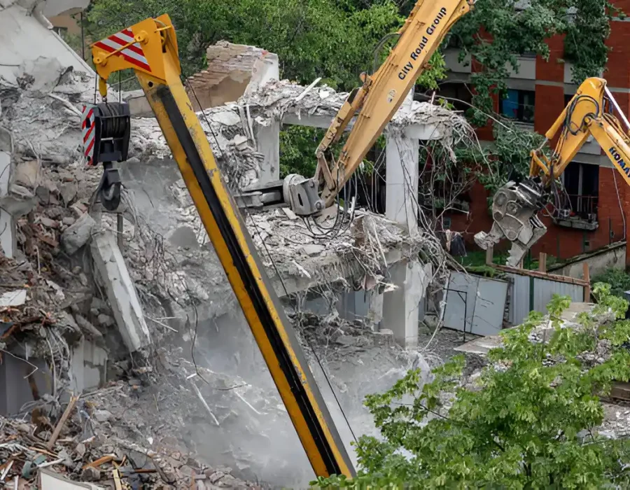 Multiple excavators working simultaneously on commercial building demolition with debris removal