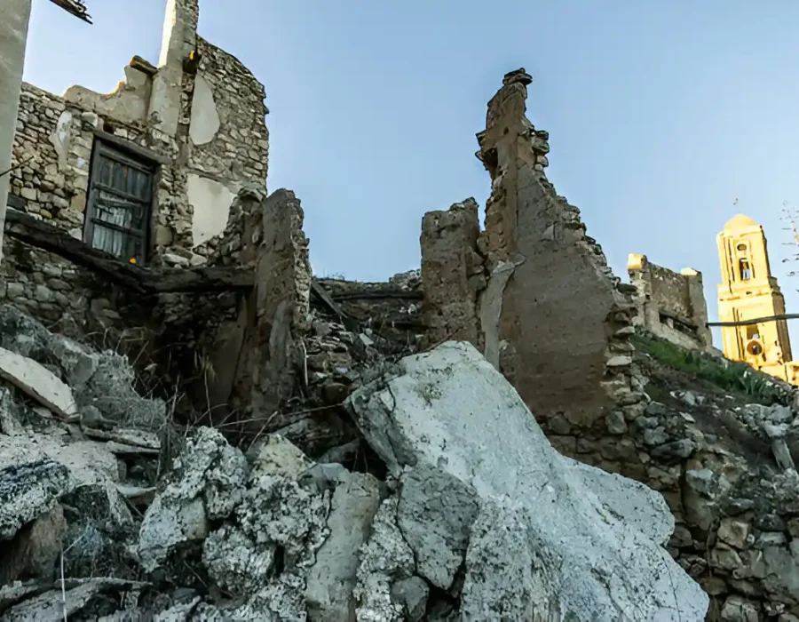 Demolished stone building ruins with large concrete debris requiring specialized removal services