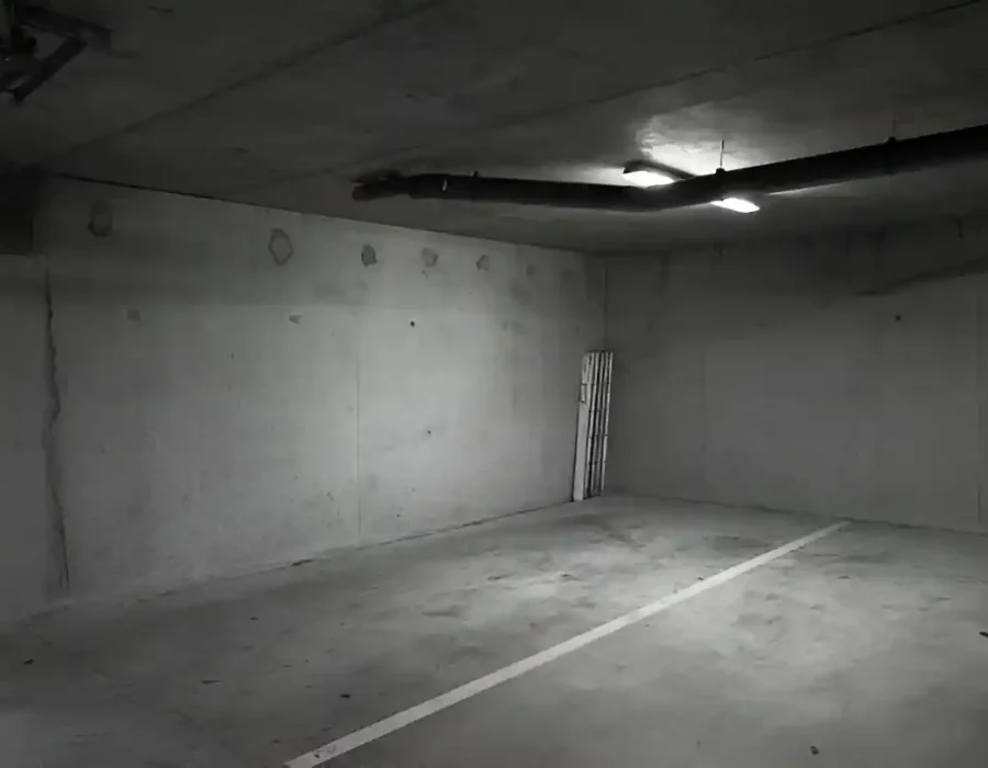 Empty concrete garage interior prepared for demolition.