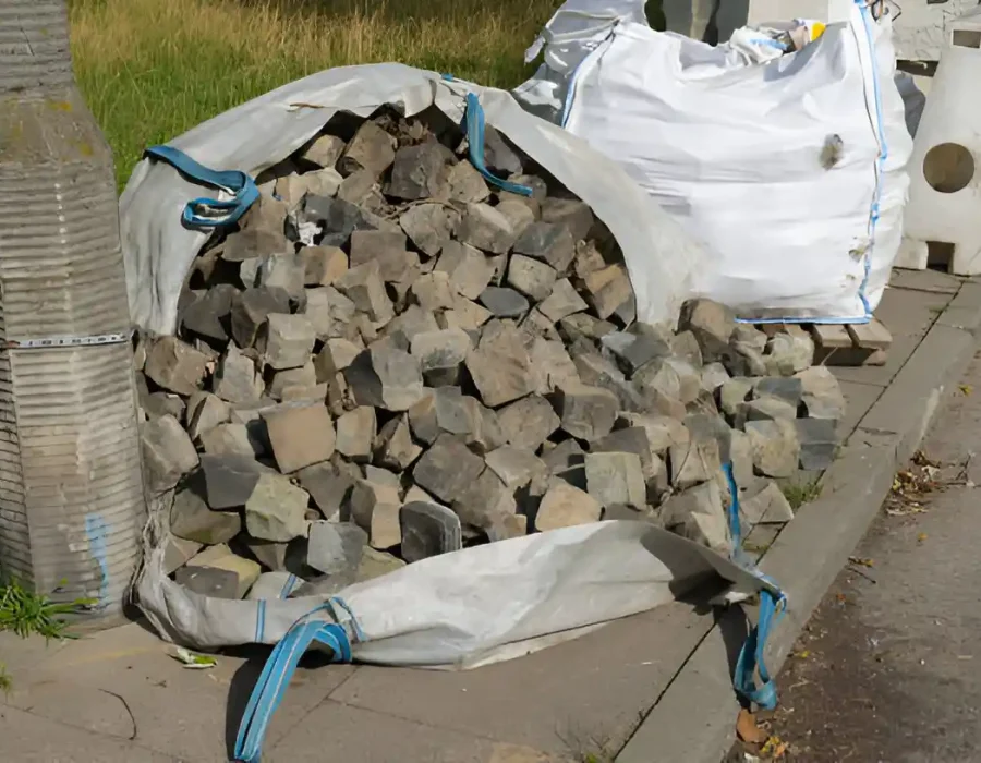 Industrial bulk bag filled with demolished concrete blocks and rubble awaiting waste collection