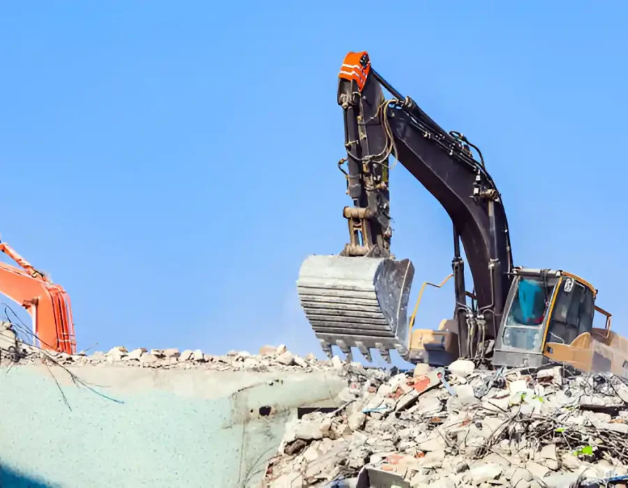Multiple excavators performing large-scale demolition and debris removal at construction site
