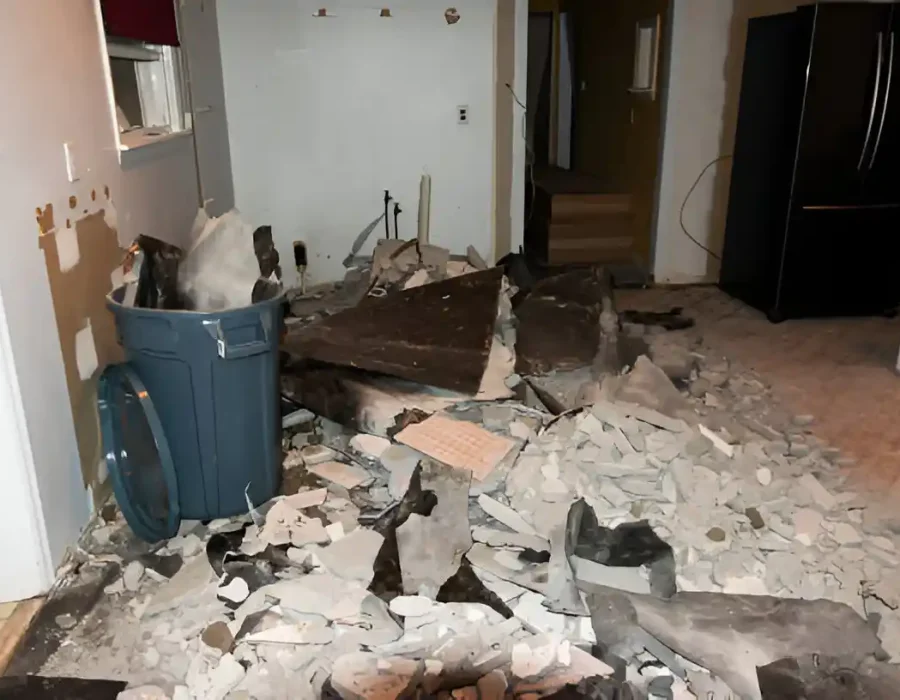 Interior demolition waste and construction debris from kitchen remodel with disposal bin
