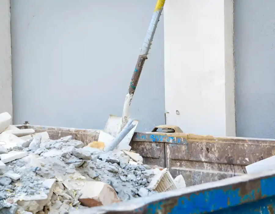 Dumpster filled with construction debris and rubble during site cleanup.