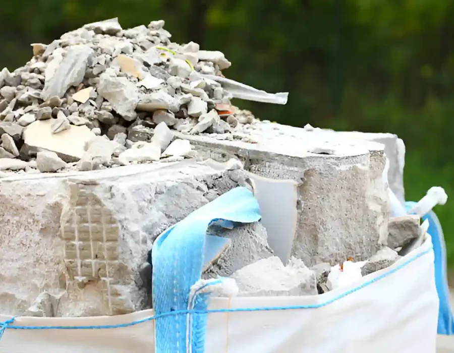 Demolition waste and concrete rubble in large white contractor bag for professional construction cleanup services