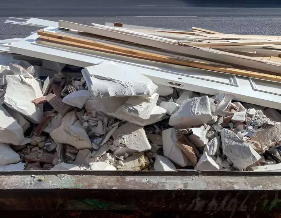 Dumpster filled with drywall, lumber and demolition waste from interior renovation project