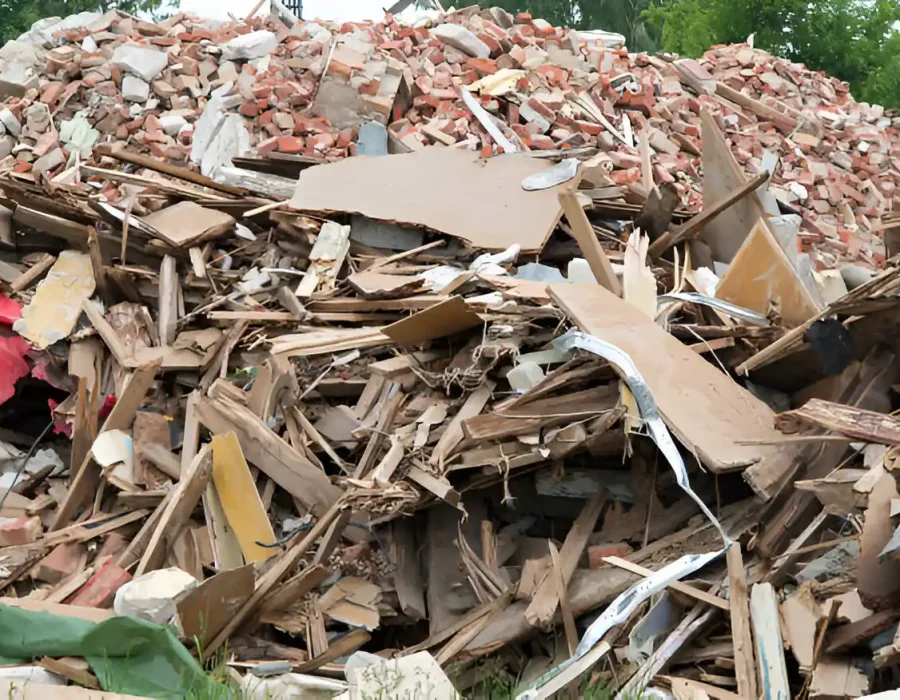 Large pile of mixed construction debris showing broken wood, brick, and building materials