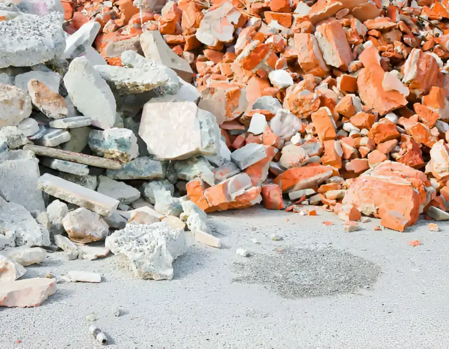 Piles of separated white concrete and orange brick rubble from building demolition cleanup