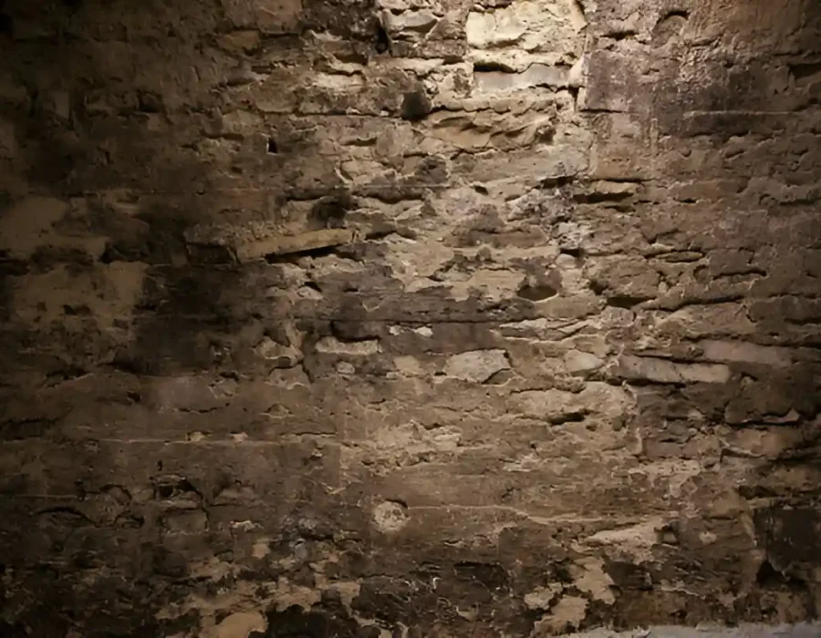 Old stone wall surface, ideal for demolition and site preparation services.