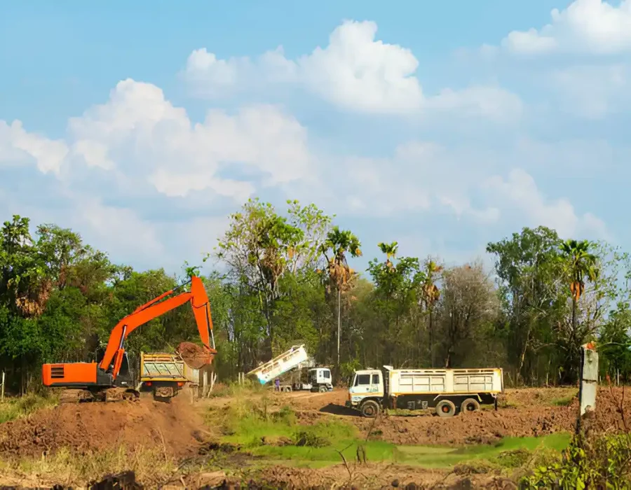 Excavator loading dirt into truck on construction site