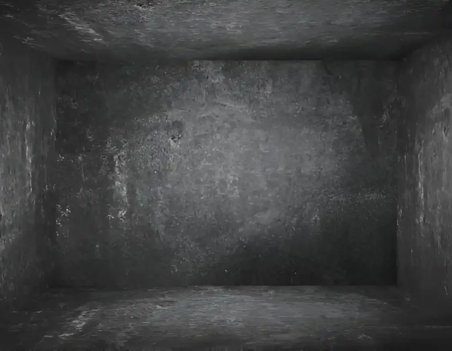 Dimly lit empty concrete room prepared for demolition services or structural renovation.
