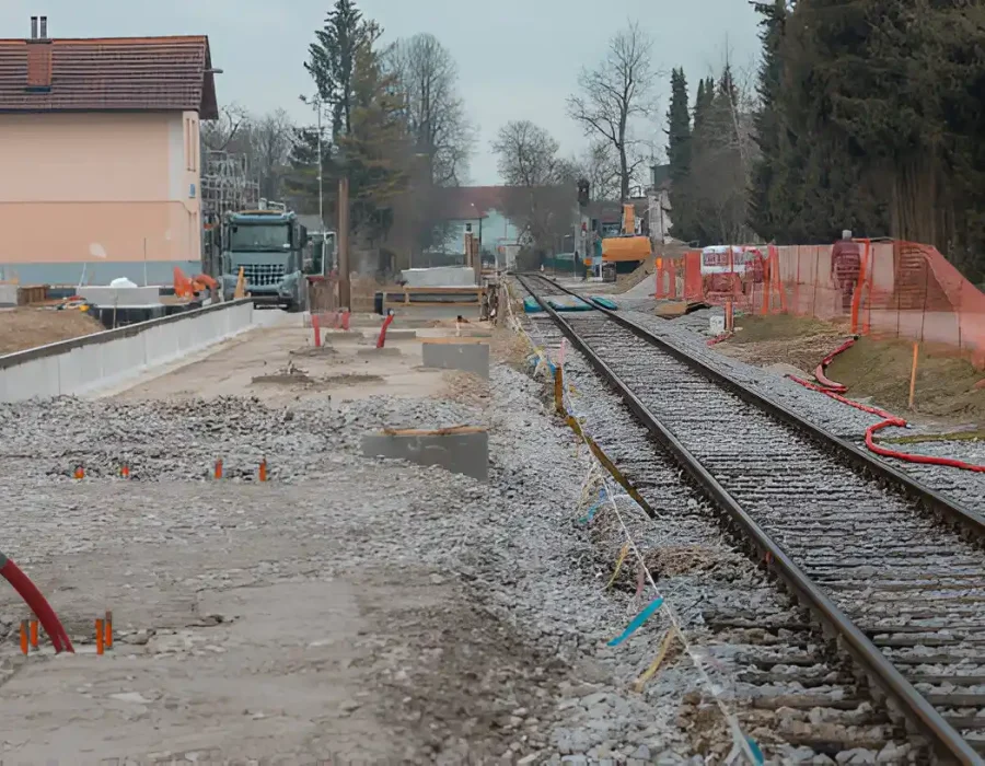 Construction along railway tracks, site preparation in progress