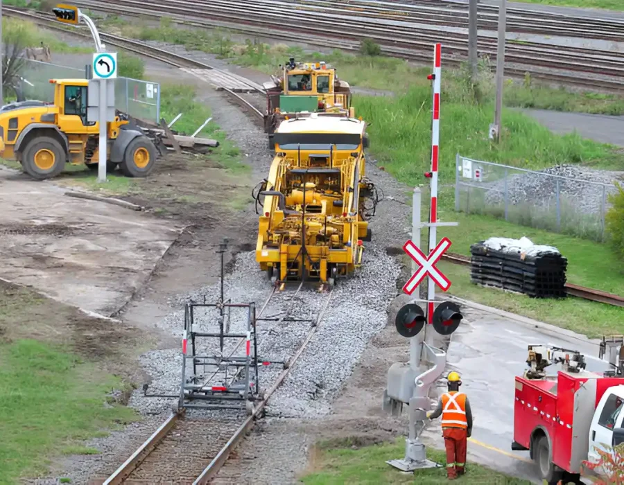 Machines and workers performing railway track maintenance
