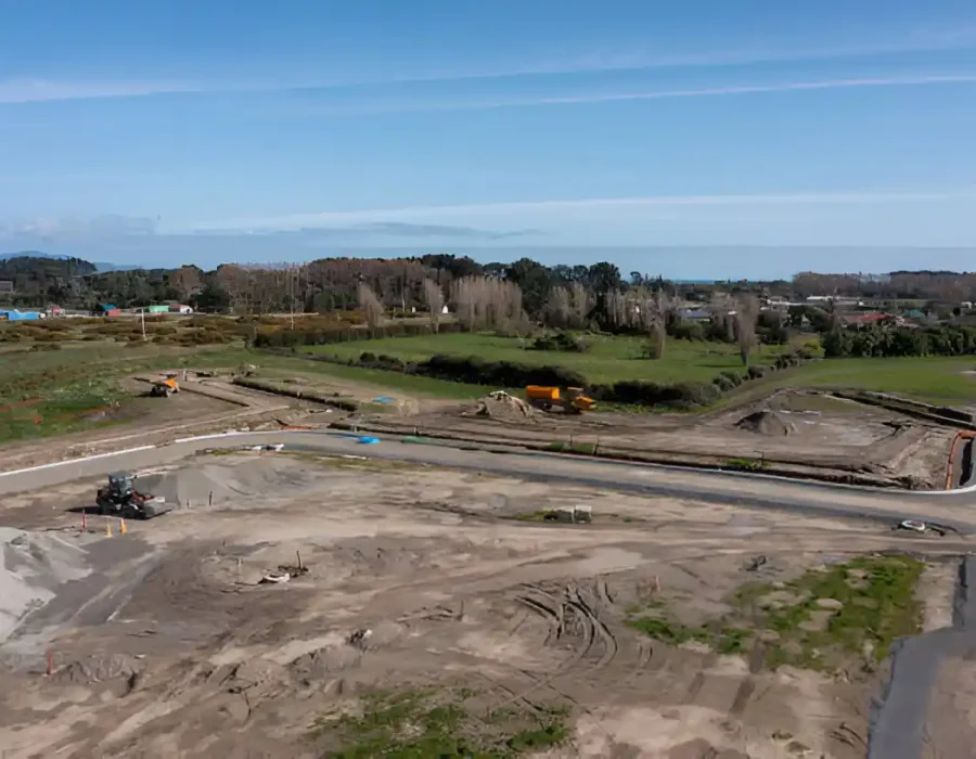 Open construction site with earthmoving equipment and clear sky