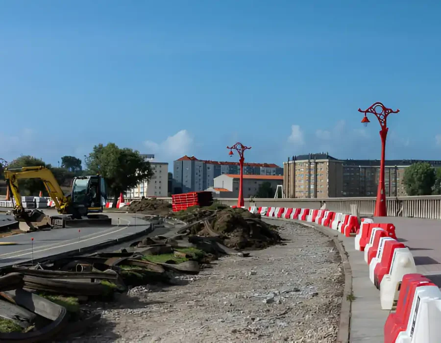 Excavator working on city road construction, barriers in place