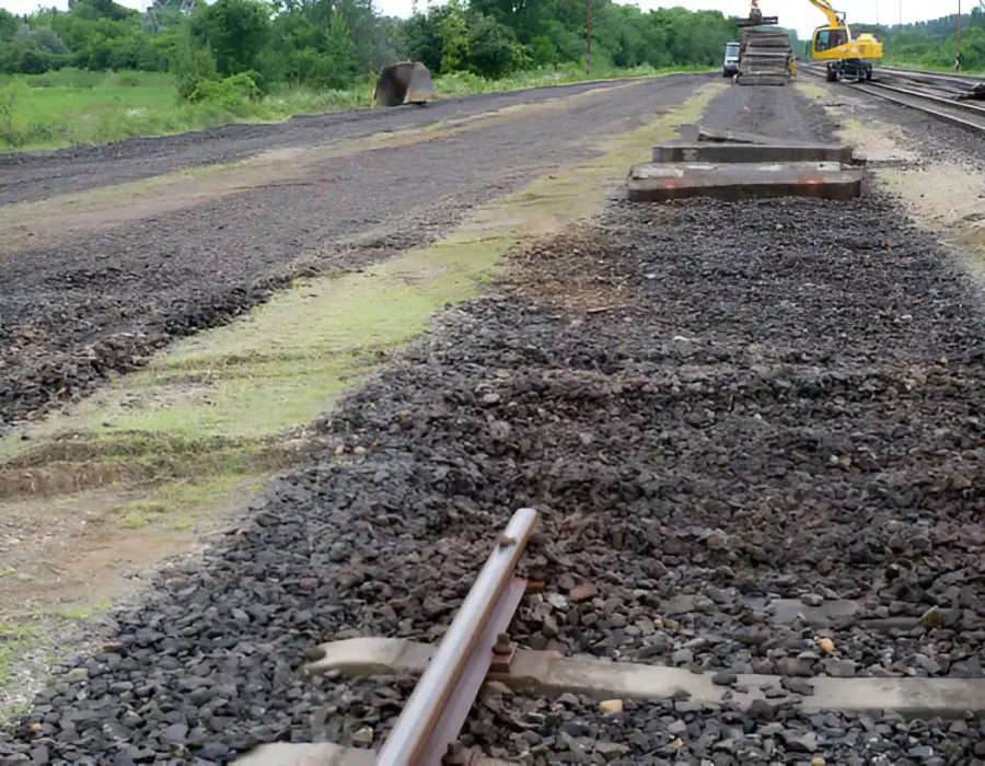 Railway track under maintenance, machinery in background