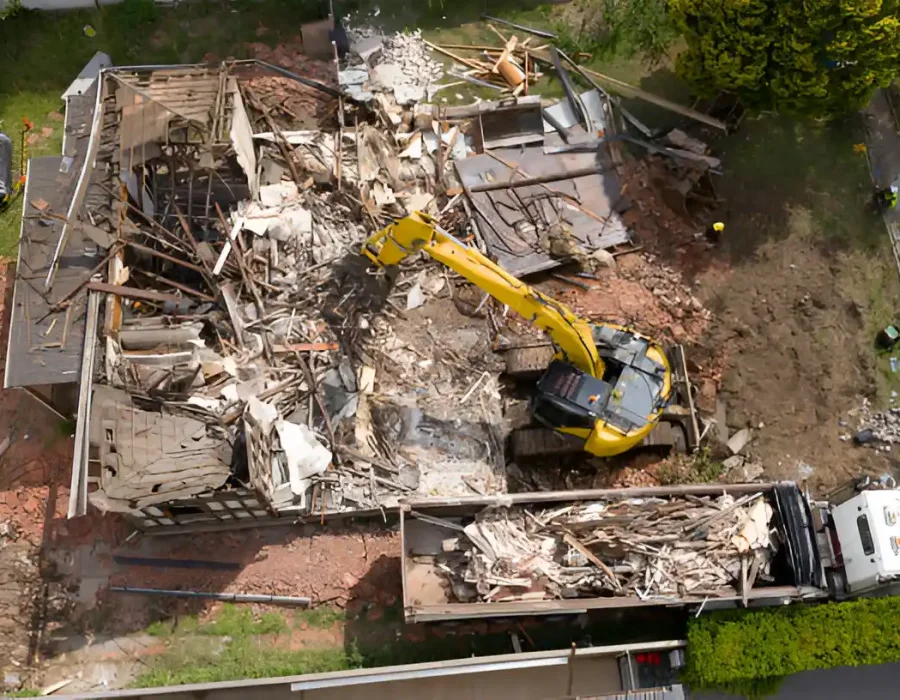 Aerial House Demolition with Excavator and Debris Load