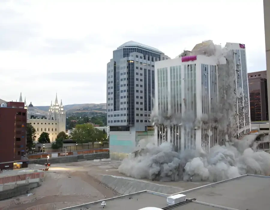 Multiple high-rise buildings collapsing with massive dust clouds in downtown demolition project