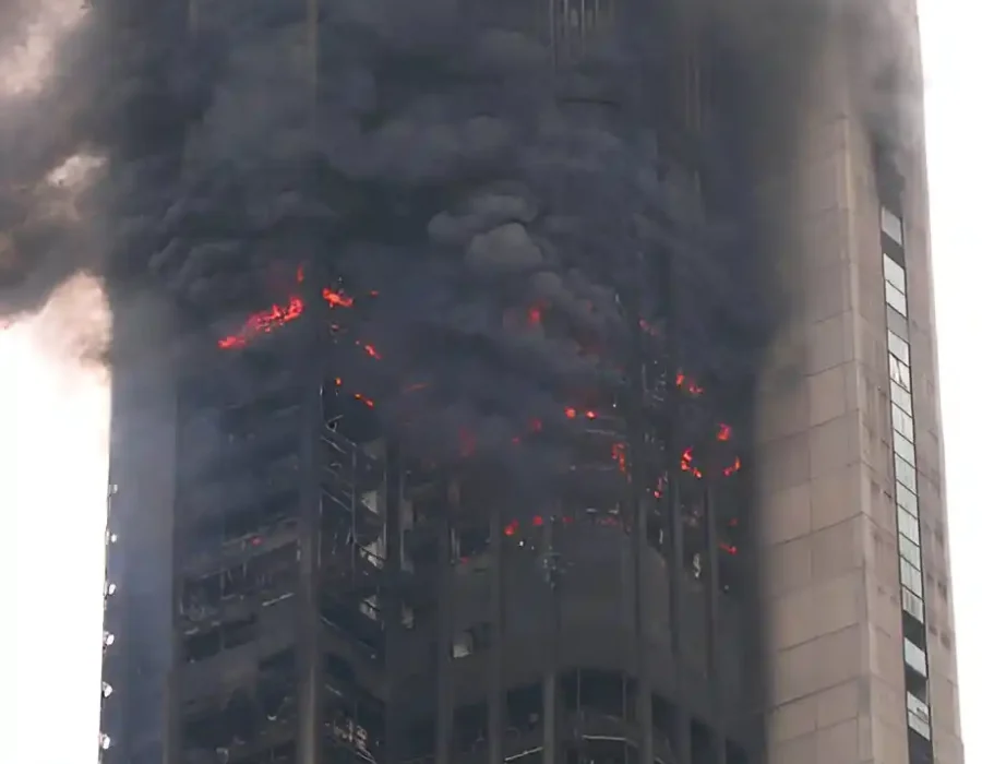 Burning high-rise building with smoke and flames, indicating need for demolition and debris removal