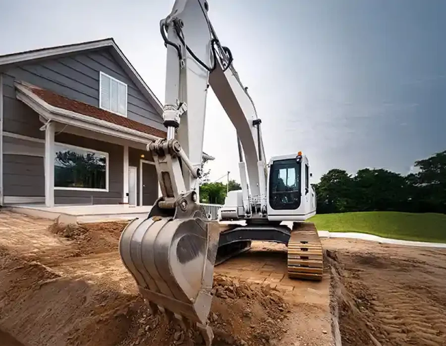 Large excavator performing residential site preparation with house in background, professional demolition equipment
