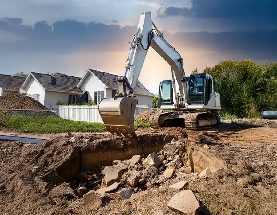 Heavy excavator performing residential demolition and site preparation work near suburban homes