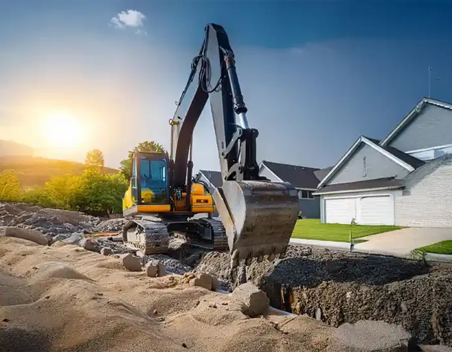 Heavy excavator performing residential demolition and site preparation work during golden hour sunset