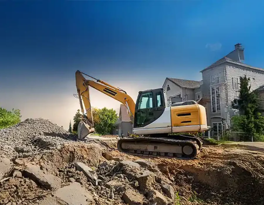 Heavy excavator performing residential demolition and debris removal with white house in background