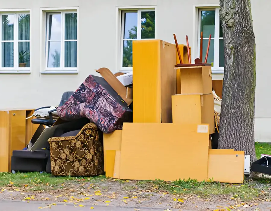 Assorted furniture stacked outside a building, ready for demolition and debris removal services
