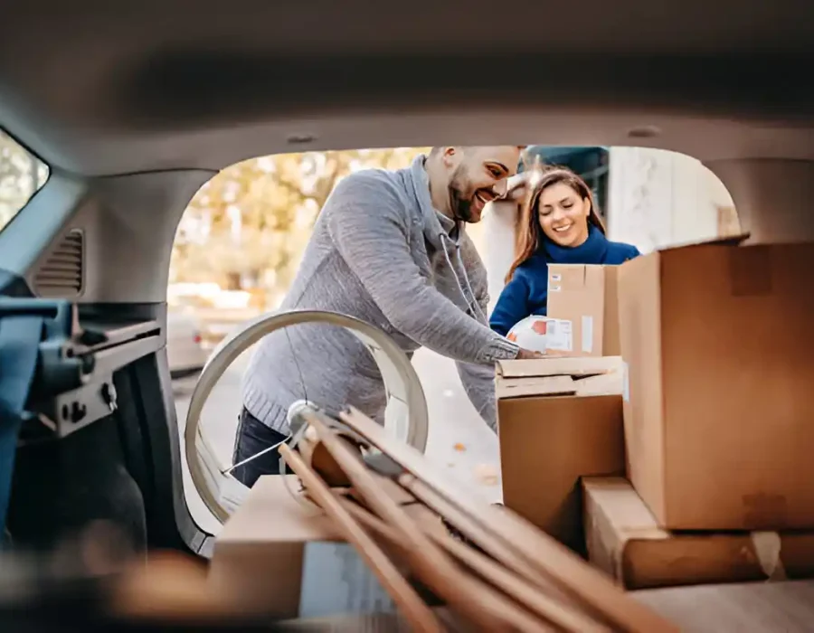 Man and woman packing boxes into a vehicle for efficient debris removal and cleanup services