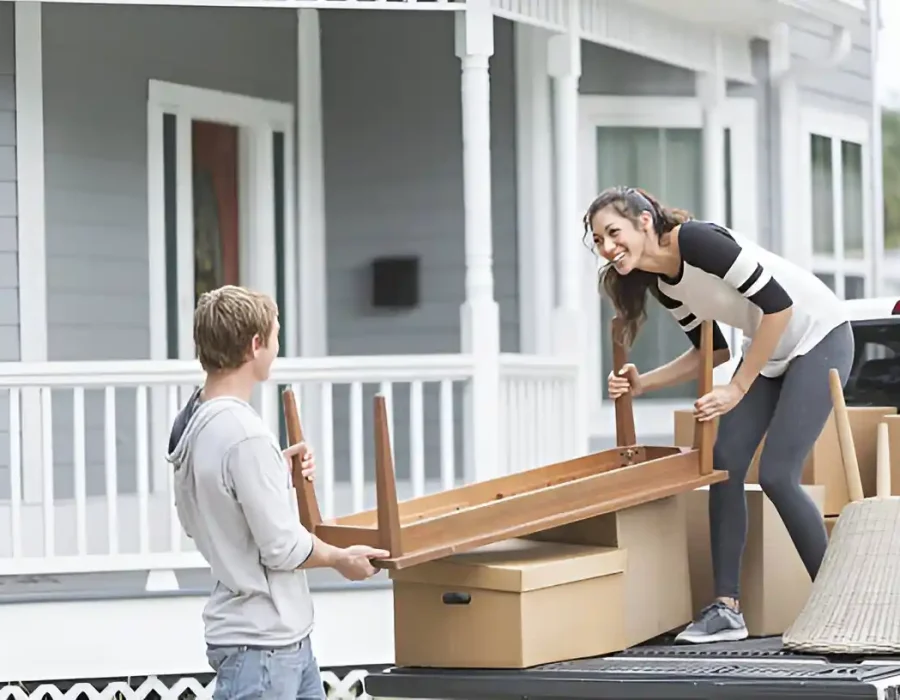 Team loading wooden furniture into truck for disposal, residential demolition and junk removal service in action