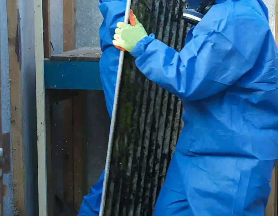 Laborer in protective gear carries debris for removal during demolition and site cleanup.