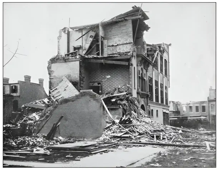 Partially demolished historic building with debris pile.