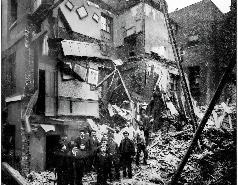 Workers stand amidst rubble during building demolition cleanup.