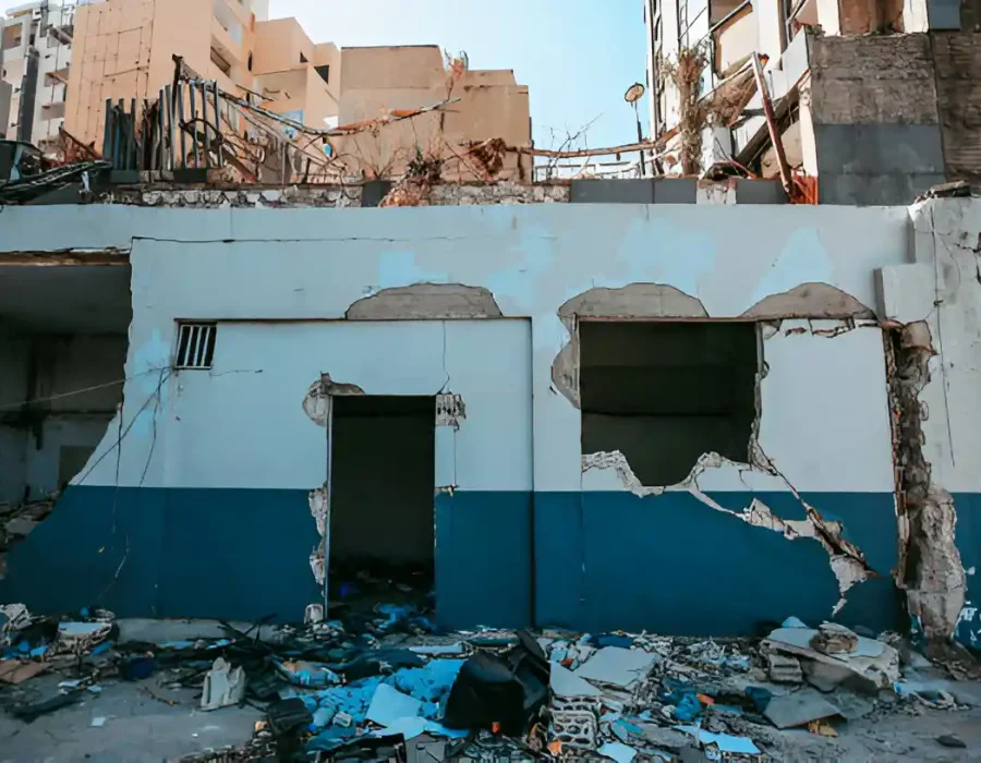 Demolished building facade with rubble and debris scattered on the ground.