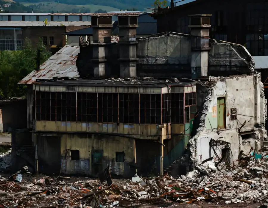 Partially demolished industrial building with debris scattered around.