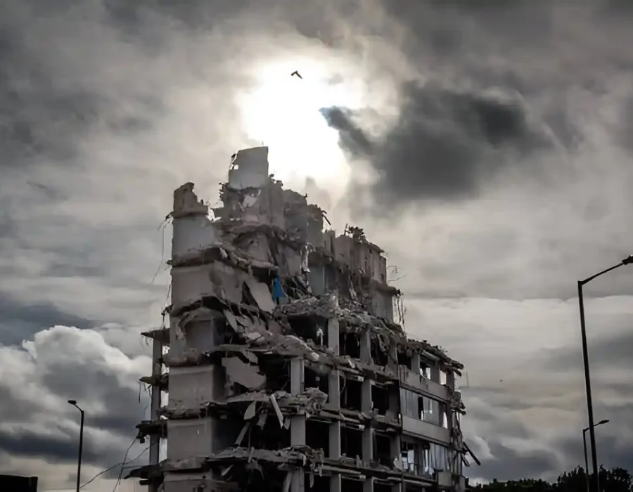 Dramatic Demolition of Structure with Debris Under Clouds