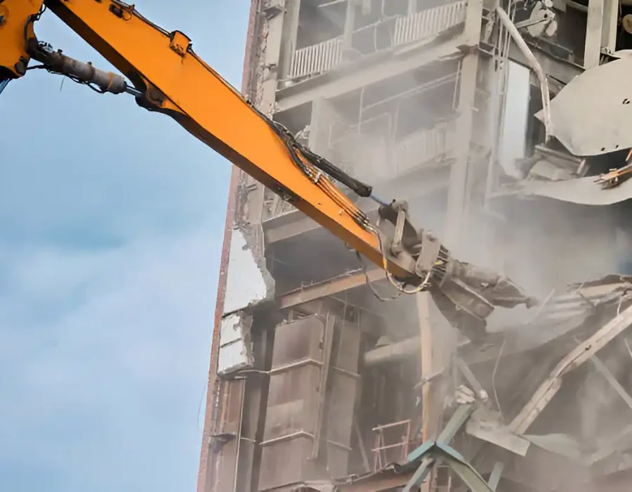 Industrial demolition machine removing multi-story structure with precision hydraulic arm