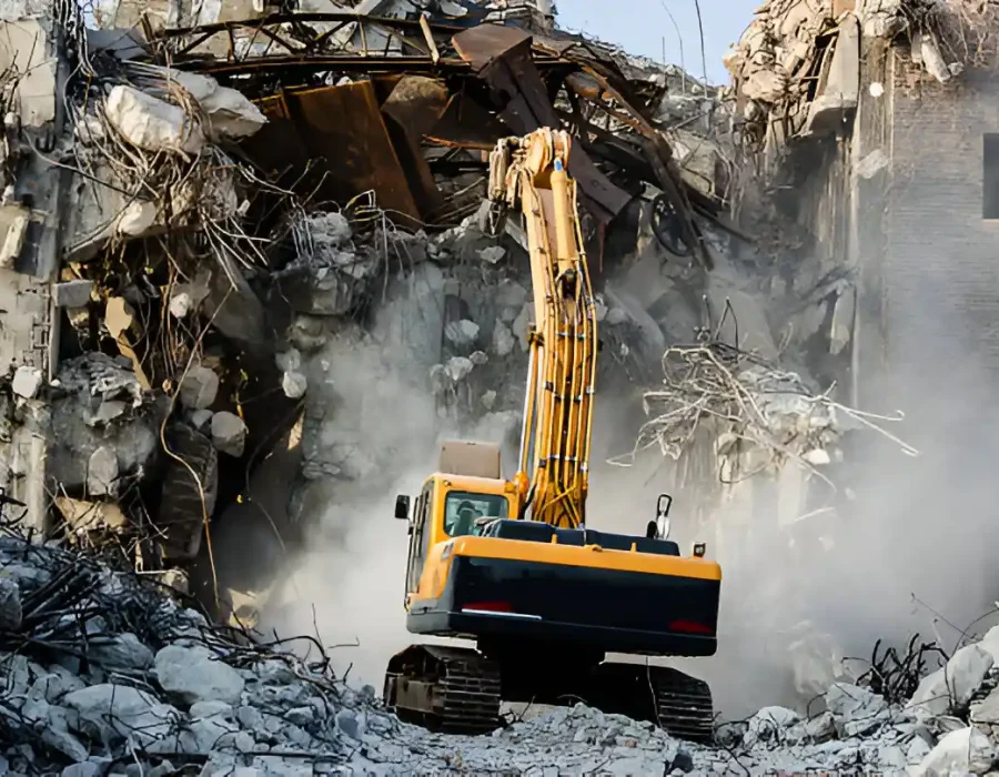 Industrial excavator demolishing concrete structure, debris removal in progress