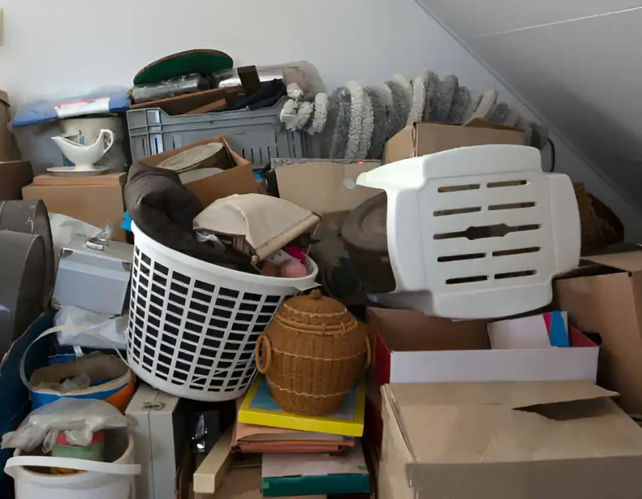 Cluttered attic storage area with household items and boxes requiring professional cleanout services