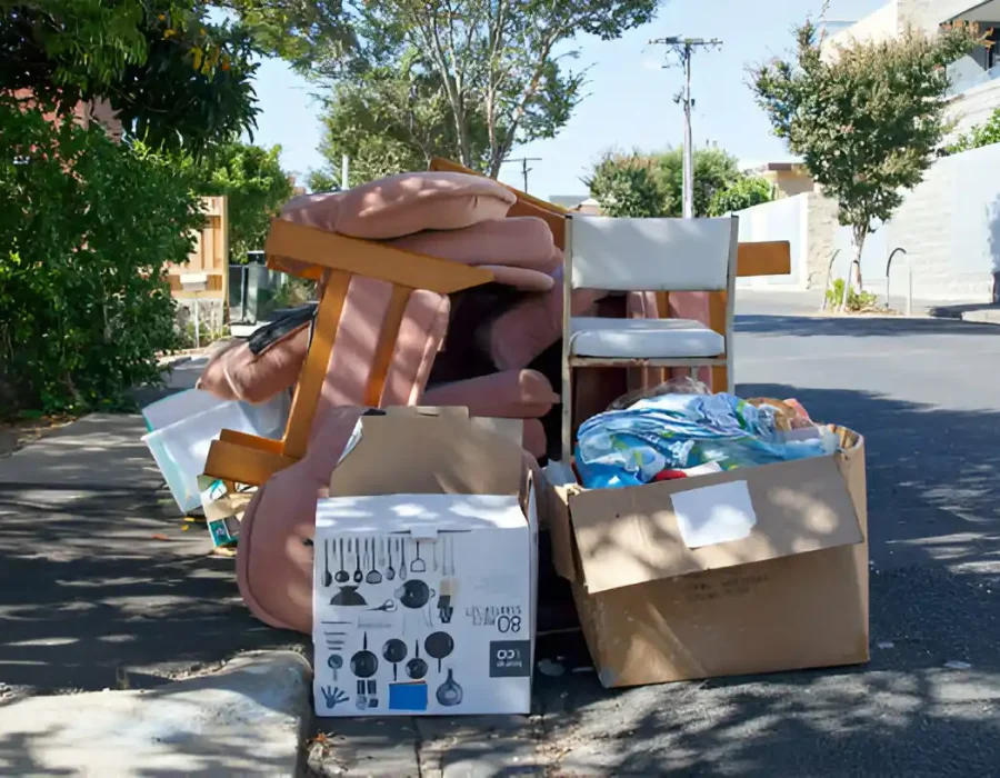 Discarded furniture and household items on street curb awaiting residential junk removal service