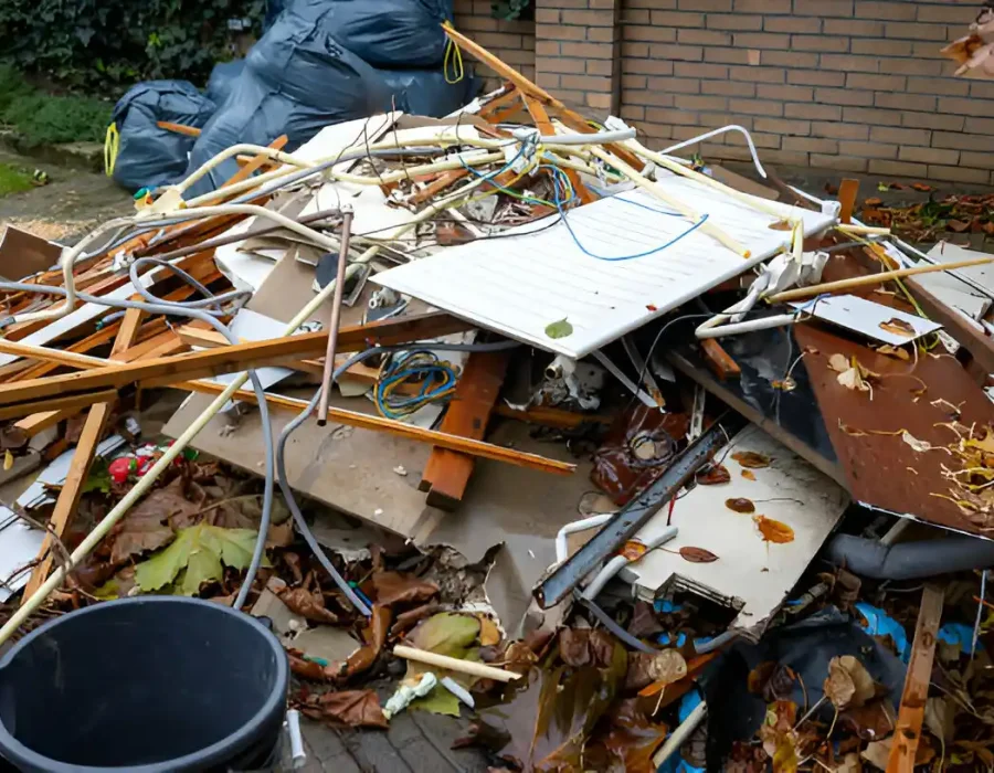 Pile of mixed demolition debris including wood, metal, and building materials ready for cleanup