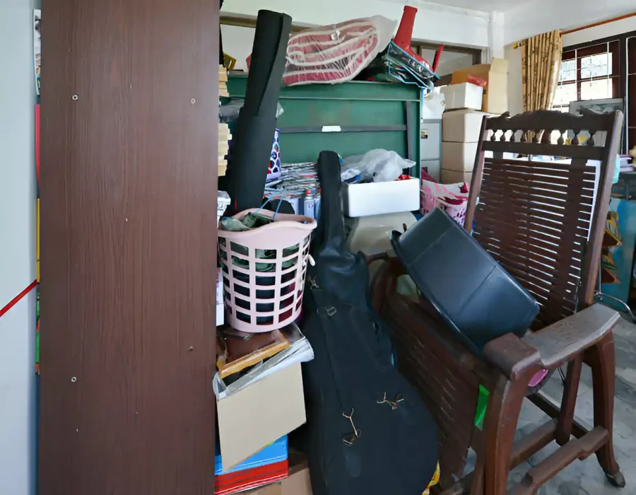 Cluttered storage space with furniture and household items requiring professional junk removal