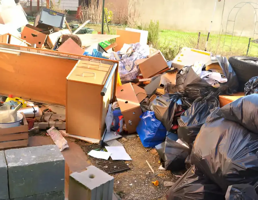 Pile of household waste, furniture, and garbage bags requiring professional junk removal services