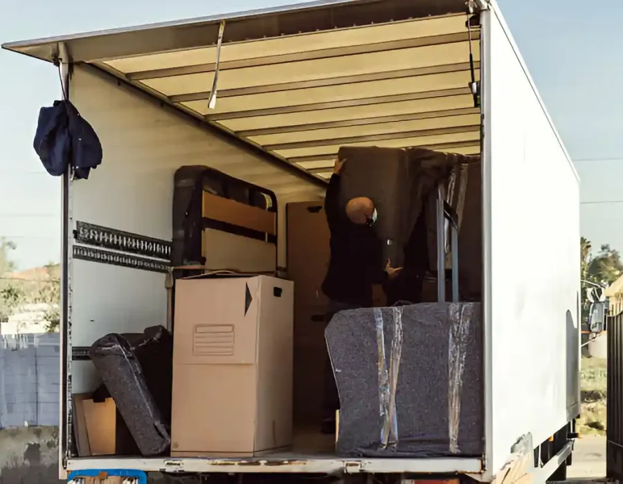 Professional removal truck being loaded with household items during cleanout service