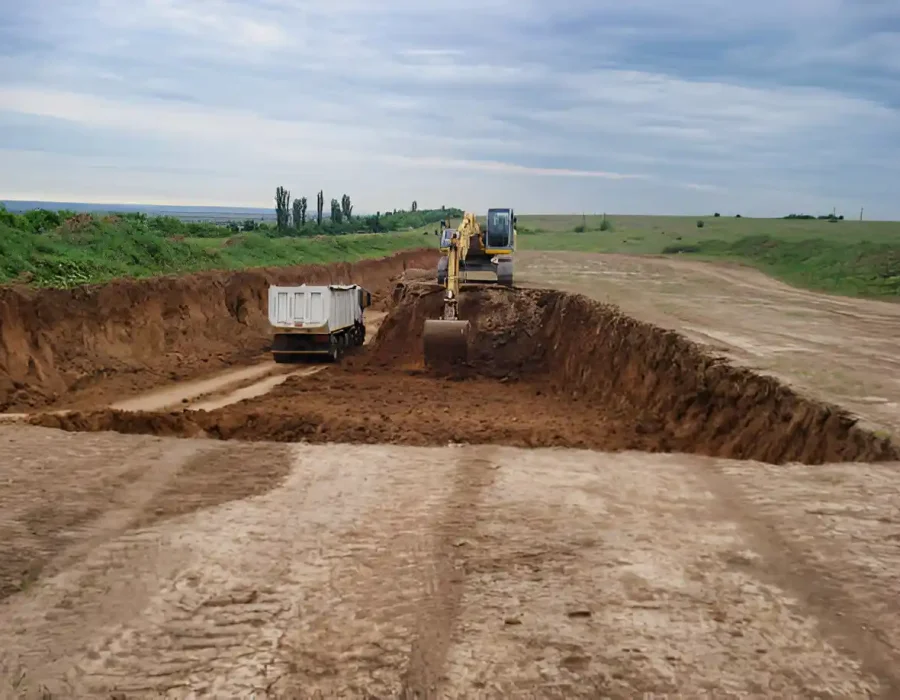 Excavator loading dump truck at construction site, heavy equipment for land clearing and earthwork services