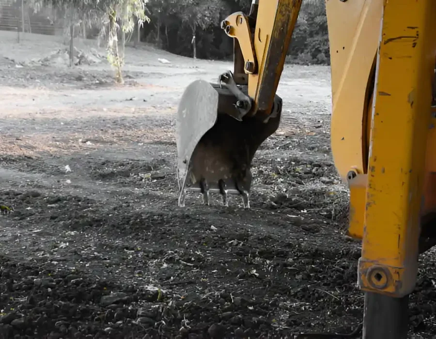 Heavy-duty excavator bucket attachment on cleared demolition ground, ready for site preparation and debris removal